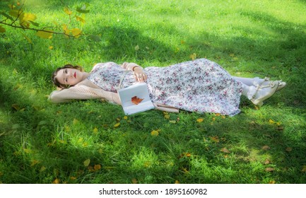 Woman With A Book Fell Sleep In Park On Grass.