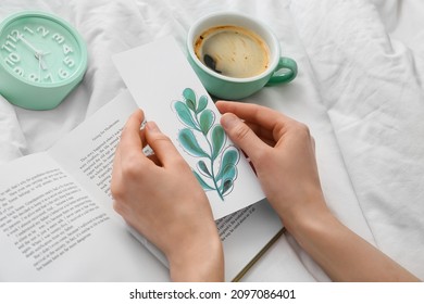 Woman with bookmark and book on bed