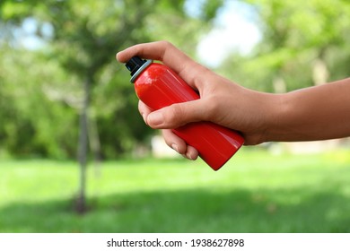 Woman With Bottle Of Insect Repellent Spray Outdoors, Closeup