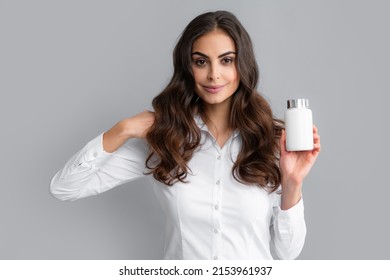 Woman with bottle pills. Happy young African American woman holding bottle of dietary supplements or vitamins in her hands. Healthy hair care concept.
