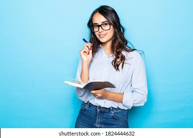 Woman Bought New Planner, Writing Down Notes Or Lecture, Smiling Joyfully, Holding Red Notebook, Decide Start Secret Diary, Standing Over Blue Background