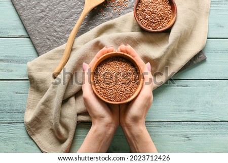 Woman with bowl of flax seeds at table