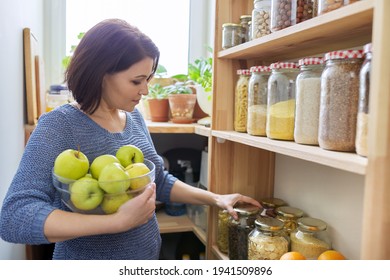 Woman With Bowl Of Green Apples In Pantry, Organizing In Kitchen