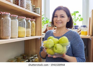 Woman With Bowl Of Green Apples In Pantry, Organizing In Kitchen