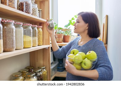 Woman With Bowl Of Green Apples In Pantry, Organizing In Kitchen