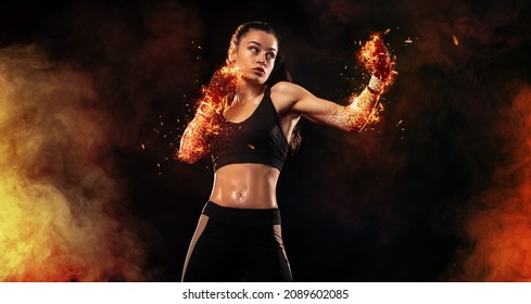 Woman boxer on black background in the fire. Boxing and fitness concept.