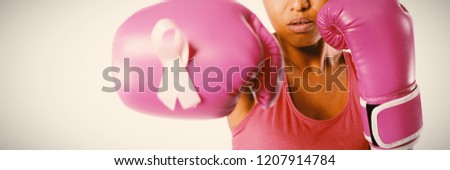 Woman in boxing gloves fighting for breast cancer awareness on white background