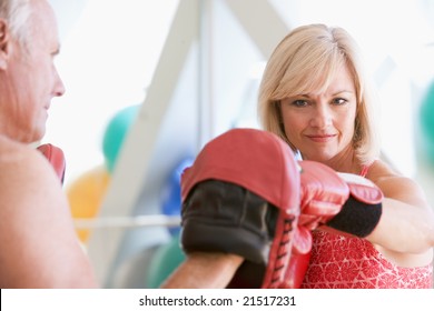 Woman Boxing With Personal Trainer At Gym - Powered by Shutterstock