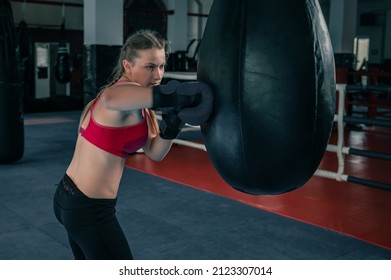 Woman Boxing With Punching Bag In Garage Gym