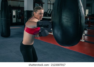 Woman Boxing With Punching Bag In Garage Gym