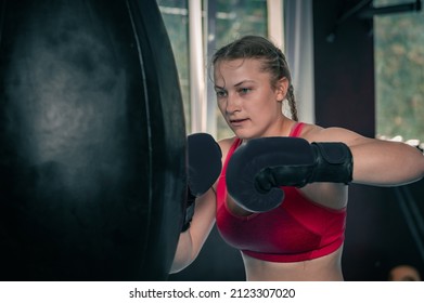 Woman Boxing With Punching Bag In Garage Gym