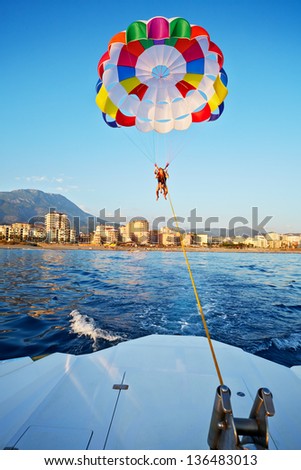 Woman and boy fly on glider over sea