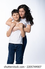 Woman With A Boy. Mom With Son On A White Background. Family Portrait In White T-shirts And Blue Jeans