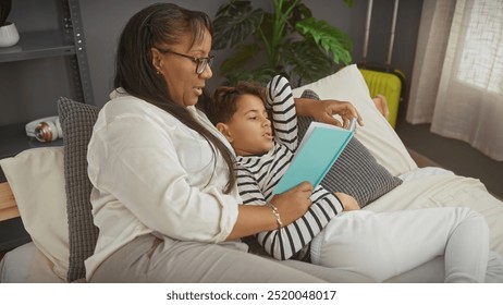 A woman and boy reading together on a bed, depicting a loving family moment in a cozy bedroom interior. - Powered by Shutterstock