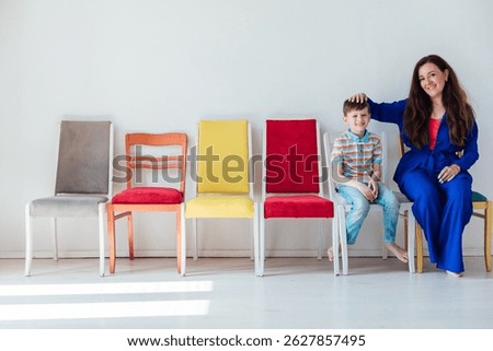 Woman and boy sitting on different chairs in room