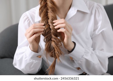 Woman with braided hair on sofa indoors, closeup - Powered by Shutterstock