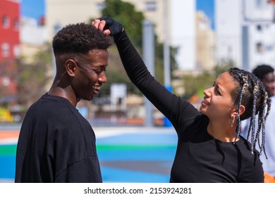 Woman with braids checks her young friend's hairstyle - Powered by Shutterstock