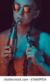 Woman With Braids Drinking Soda From Water Bottle With Straw