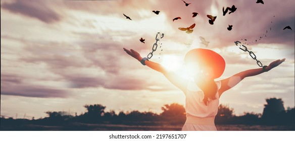 The woman is breaking the chains and setting the birds free, enjoying the nature at sunrise. concept of freedom