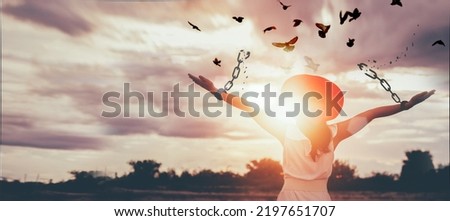 The woman is breaking the chains and setting the birds free, enjoying the nature at sunrise. concept of freedom