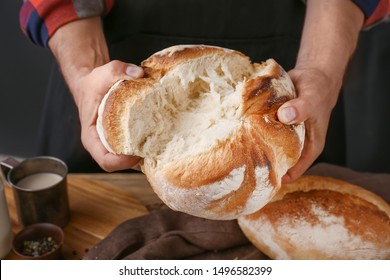 Woman breaking fresh bread, closeup