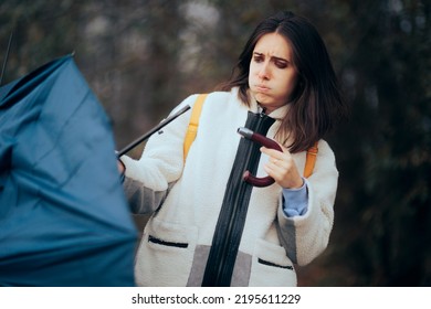 
Woman Breaking The Handle Of Her Umbrella During Rainstorm. Clumsy Person Having Bad Luck During Bad Cold Weather
