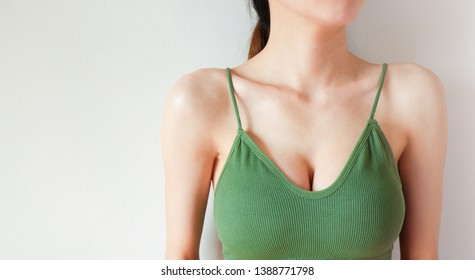 Woman is Breast in Green Underwear Posing on Grey Background,Show the Bra. Cropped Close Up of Sexy Female Wearing Sport Bra (Sportswear) with Perfect Chest. Fitness and Yoga Healthy Lifestyle Concept