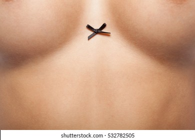 Woman Breast With Little Black Bow.