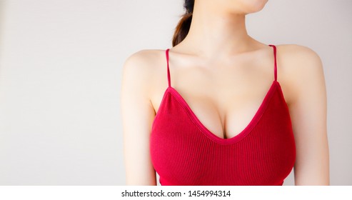 Woman is Breast in Red Underwear Posing on Grey Background,Show the Bra. Cropped Close Up of Sexy Female Wearing Sport Bra (Sportswear) with Perfect Chest. Fitness and Yoga Healthy Lifestyle Concept.