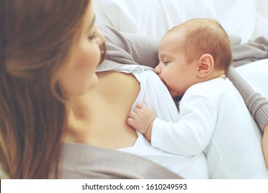 A woman is breastfeeding a baby. Mom and a small child.
