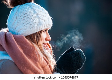 Woman Breathing On Her Hands To Keep Them Warm At Cold Winter Day