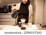 A woman brewing coffee in her kitchen at home