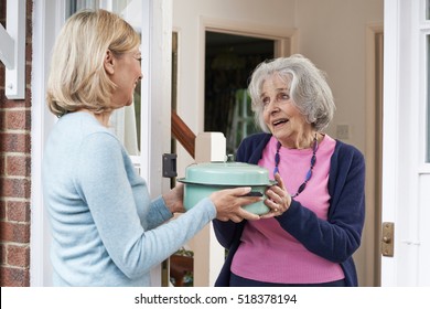 Woman Bringing Meal For Elderly Neighbour