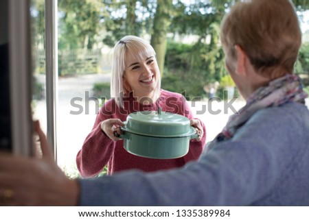 Woman Bringing Meal For Elderly Neighbour