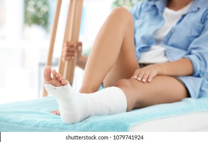 Woman With Broken Leg In Cast On Couch