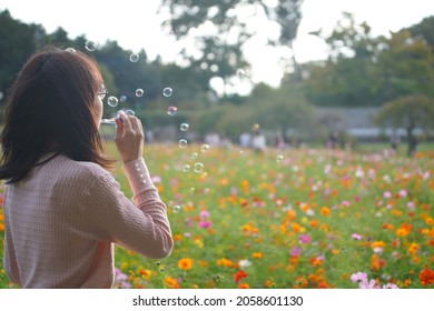 Woman Brow Soap Bubbles At Cosmos Field