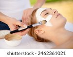 Woman, brush and facial mask at spa, outdoor treatment and detox or cleaning dermatology. Female person, self care and chemical peeling or skincare to apply, cosmetics and exfoliate clay for acne