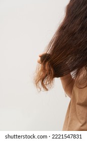 Woman Brush Her Dry And Frizzy Natural Curly Hair That Needs Hydration. Natural Curls Before Salon Treatment. Close Up.