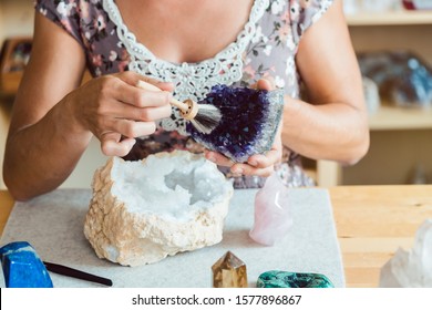 Woman brushing an amethyst in her workshop