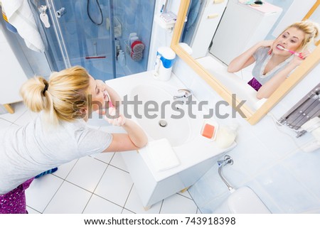 Woman brushing cleaning teeth closeup. Funny blonde girl with toothbrush in bathroom. Oral hygiene. Unusual wide angle view