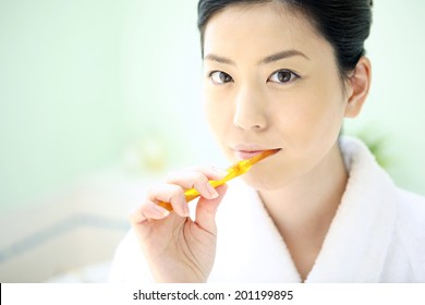 Woman brushing her teeth - Powered by Shutterstock