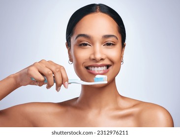 Mujer, cepillado de dientes y retrato de estudio con sonrisa para auto cuidado, bienestar dental o salud por fondo blanco. Chica, modelo odontológico y cepillo de dientes con dentífrico, producto y feliz de limpiar