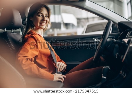 Woman buckles up the safety belt in a car 商業照片 © 