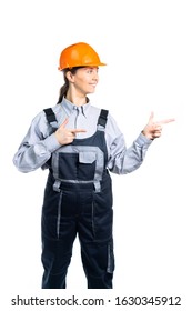 A Woman Builder Looks To The Right And Shows With Both Hands In The Same Direction. Isolated