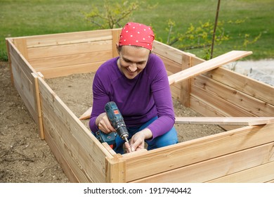 Woman Building A Wooden Frame Using Power Drill.
 DIY Concept. Powerful Woman.