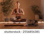 woman burning aroma stick for meditation and yoga in cozy warm atmosphere of room