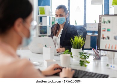 Woman In Business New Normal Office Working On Laptop Behind Shiled Keeping Social Distancing During Global Outbreak With Covid19 Flu, Wearing Face Mask To Prevent Infection.