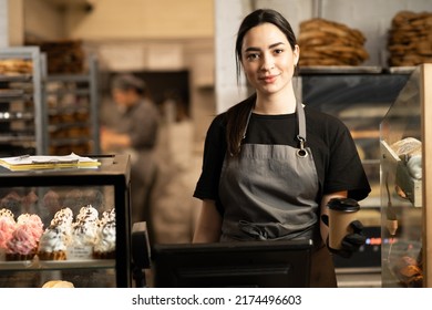 woman business owner with bakery shop background near showcases with pastries, girl working in a cafe - Shutterstock ID 2174496603