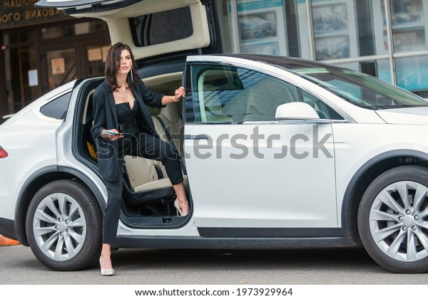 a\
woman in a business suit sits in the back seat of a\
car