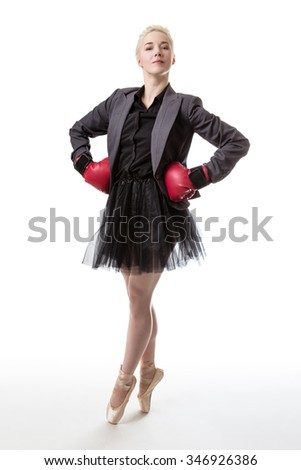 Woman in a business suit and a tutu, wearing boxing gloves
